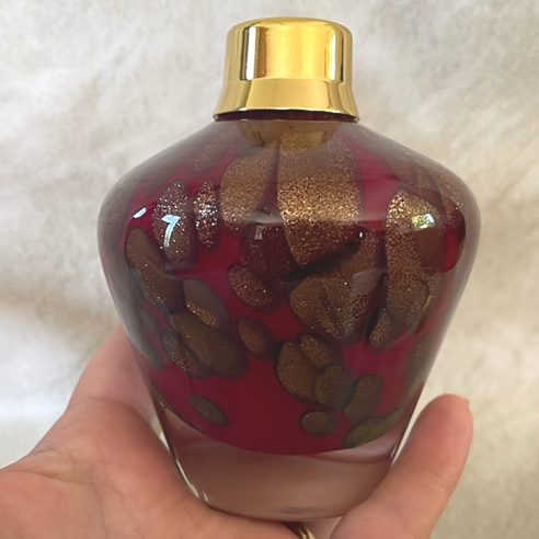 Vaporisateur de parfum poire verre artisanal bordeaux or bronze 150 ml porté en main Vaporisateur de parfum poire verre artisanal bordeaux or bronze 150 ml porté en main