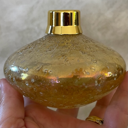 Vaporisateur de parfum artisanal en verre irisé martelé poire couleur or en main