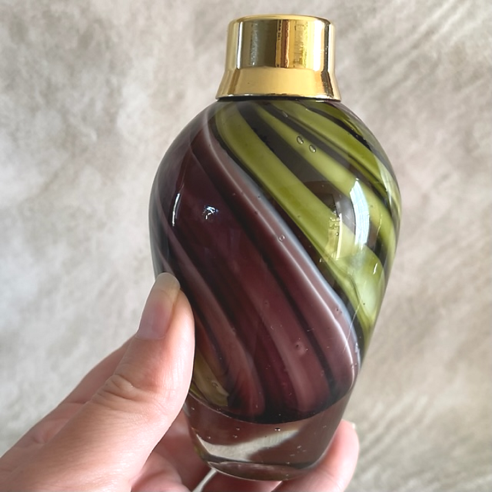 Vaporisateur de parfum artisanal multicolore aubergine kaki poire aubergine 100 ml en main