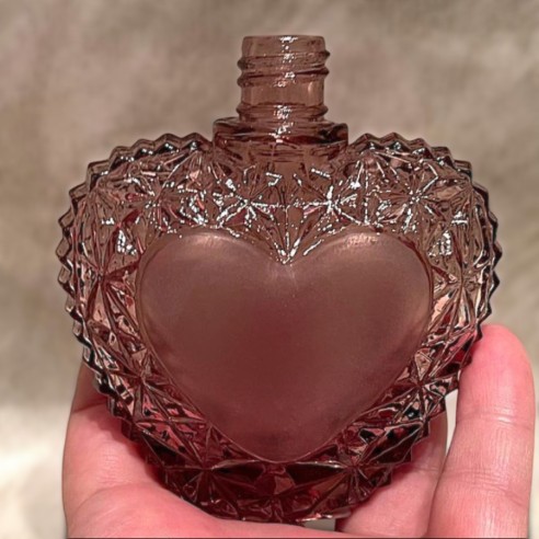 Vaporisateur de parfum cœur artisanal en cristal rose en main Vaporisateur de parfum cœur artisanal en cristal rose en main